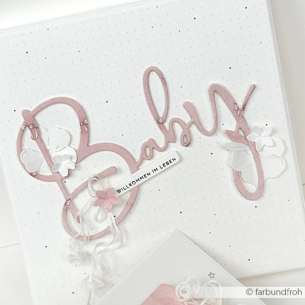 Grußkarte von Alexandra Renke mit "Baby" in rosafarbener Schrift, weißen Blumenakzenten und gepunktetem Hintergrund - ideal für Papierprojekte oder zur Präsentation von Lieblingsdesignpapier wie Schleifengewusel Rosa.