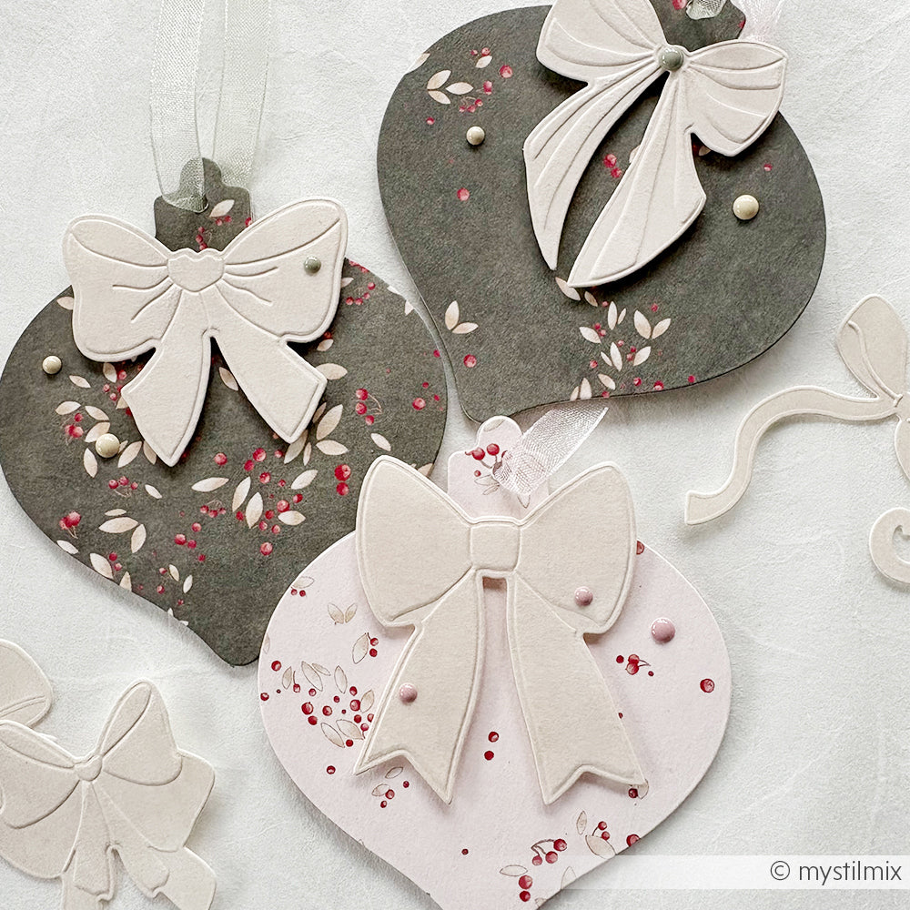 Papierornamente in Form von Kugeln mit Schleifen, mit floralen Mustern in Rosa, Weiß und Grau - perfekt für Papierprojekte oder zur Ergänzung Ihrer Buchbinderei-Kreationen mit dem Designpapier Beerenwirbel Avocado von Alexandra Renke.