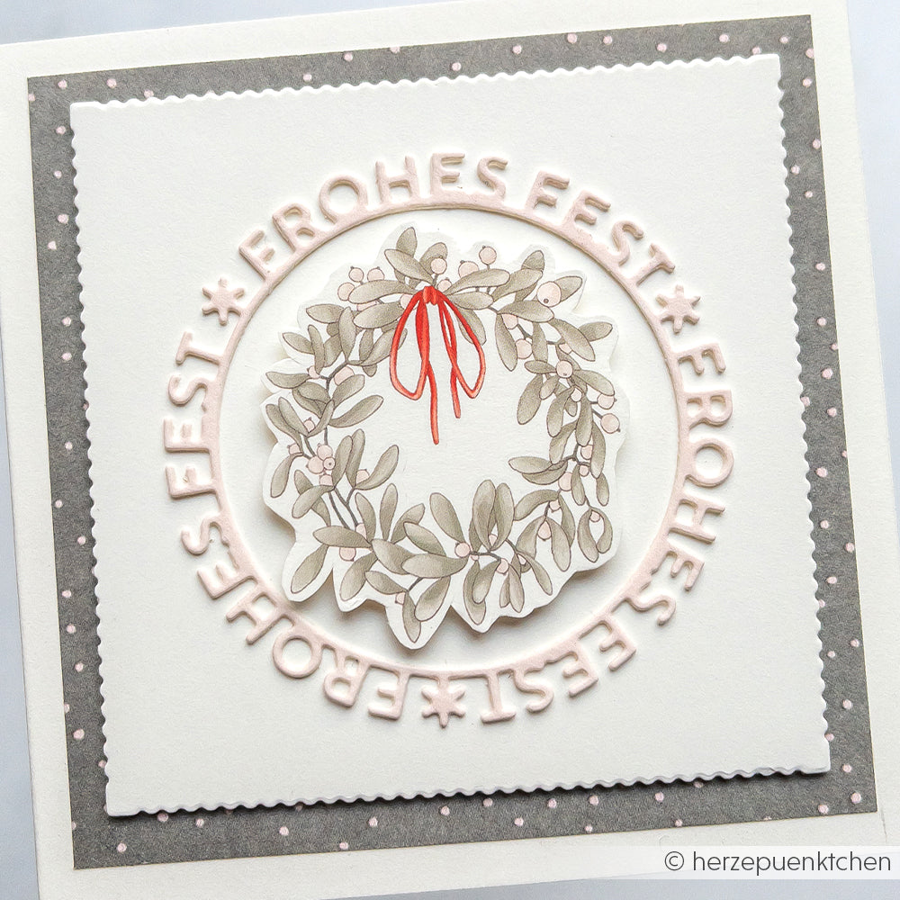 Die Grußkarte von Alexandra Renke zeigt einen Kranz mit roter Schleife und "FROHES FEST" in einem Kreis - ideal für Papierprojekte oder zum Hervorheben Ihres Lieblingsdesignpapiers.