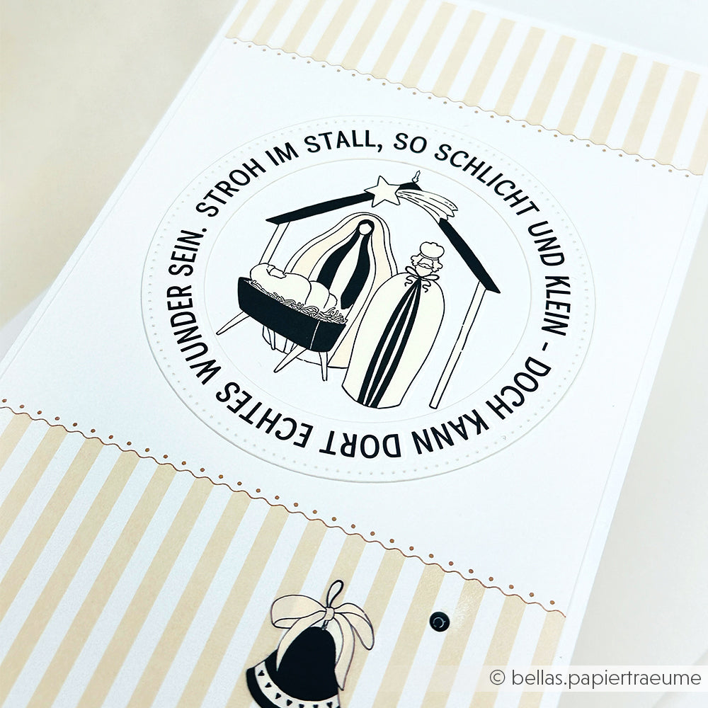 Eine minimale Krippenillustration mit deutschem Text in einem runden Design auf gestreiftem Designpapier von Alexandra Renke.