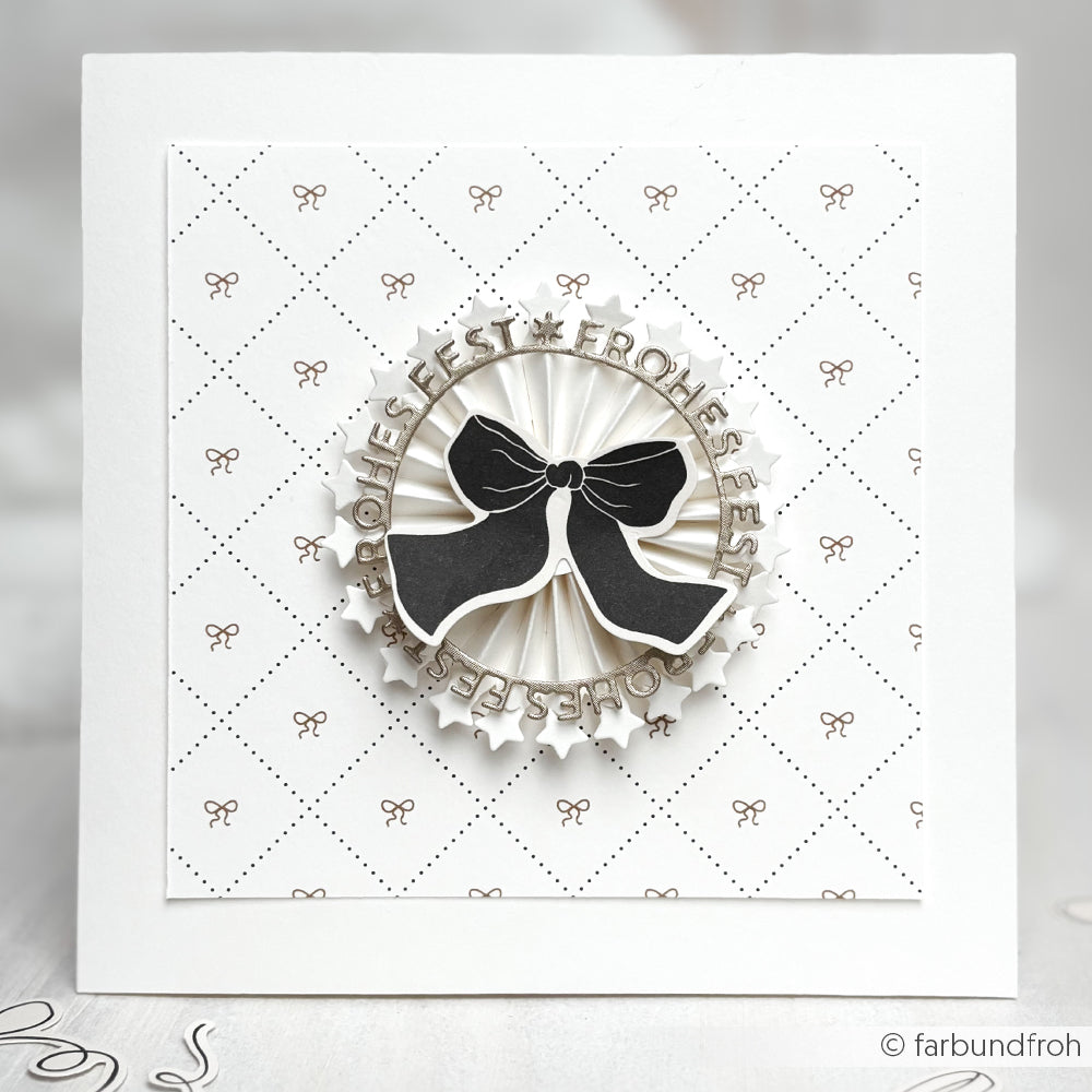 Eine handgefertigte Weihnachtskarte von Alexandra Renke mit einer schwarzen Schleife und einem Wellenkreis auf Designpapier, perfekt für Ihre Papierprojekte.