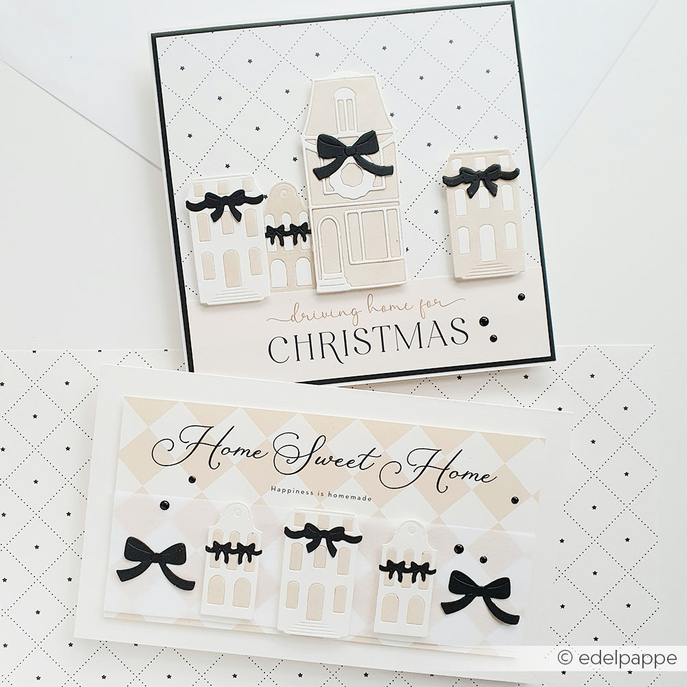 Zwei handgefertigte Weihnachtskarten von Alexandra Renke mit beigen Häusern und schwarzen Schleifen auf weiß gemustertem Hintergrund, gestaltet mit Designpapier und akzentuiert mit Karoraster Sterne klein für charmante Papierprojekte.