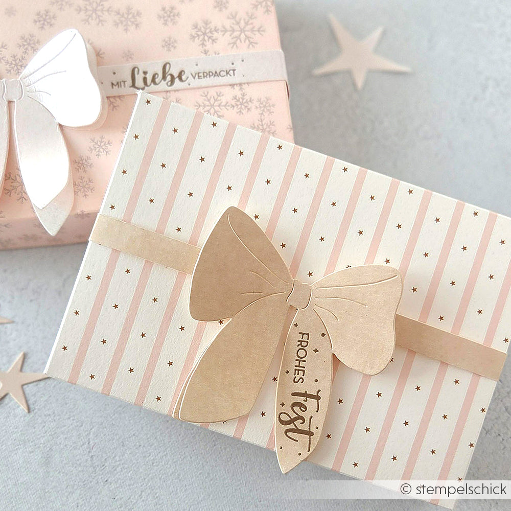 Zwei pastellfarbene Geschenkboxen mit Stern- und Streifenmuster aus dem Designpapier Sternenstreifen Rosa von Alexandra Renke, jeweils mit einer großen Papierschleife und einem festlichen Anhänger versehen - ideal für kreative Papierprojekte oder Buchbinderei-Geschenke.