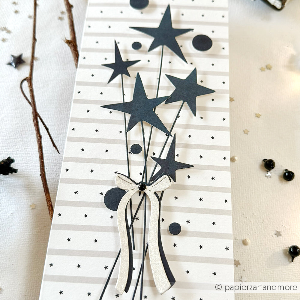 Eine Karte mit schwarzen Sternenballons und einer Schleife auf Weiß, verziert mit Sternen und Streifen, inspiriert von Alexandra Renke's Designpapier Sternenstreifen Grau - ideal für Papierprojekte oder kreative Buchbinderei.