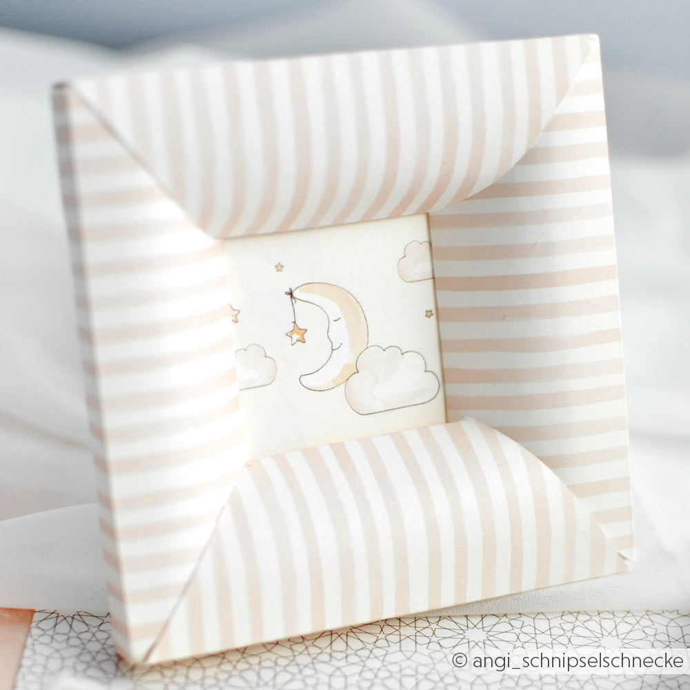 Origami-Bilderrahmen mit Alexandra Renke Designpapier Streifen rosa, der eine Mondsichel, Sterne und Wolken zeigt - ideal für Papierprojekte oder buchbinderische Akzente.