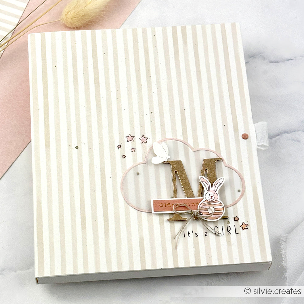 Dieses rosa-weiß gestreifte Baby-Mädchen-Scrapbook von Alexandra Renke besticht durch seine Buchbinderei, eine Wolke, einen Hasen und den Holzbuchstaben N auf dem Cover. Hergestellt mit hochwertigem Designpapier Streifen warmgrau-perfekt für Papierprojekte.