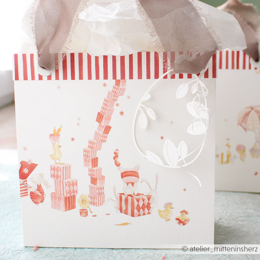 Geschenktüte von Alexandra Renke mit skurrilen Tierillustrationen, roten Streifen, Seidenpapier und einem weißen Blattanhänger - ideal für Papierprojekte oder als Inspiration für Buchbinderei-Designpapierprojekte.