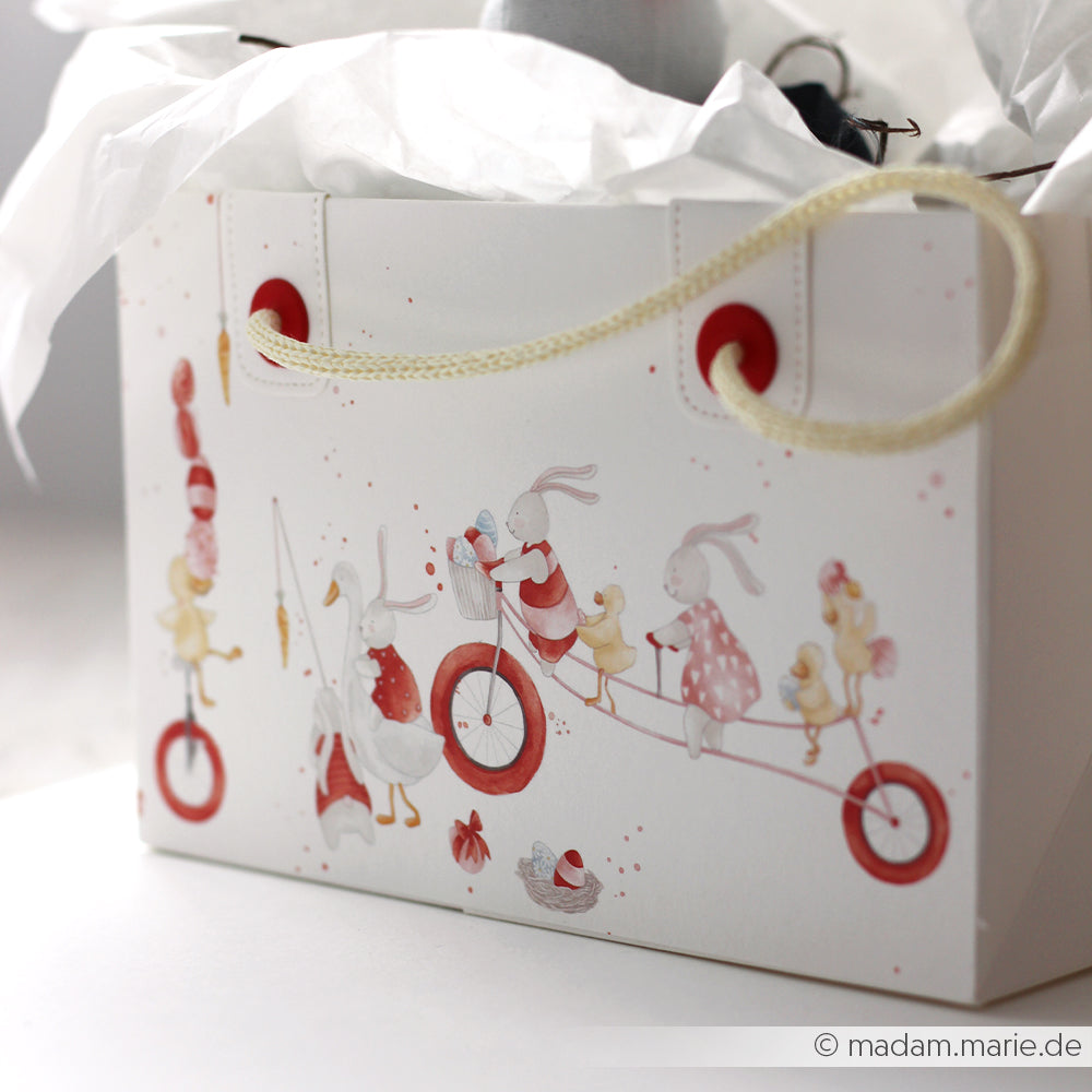 Weiße Geschenktasche von Alexandra Renke mit Tierillustrationen - Hasen und Enten auf einem roten Tandemfahrrad - ideal für Papierprojekte oder inspiriert von der Designpapier Osterparade.