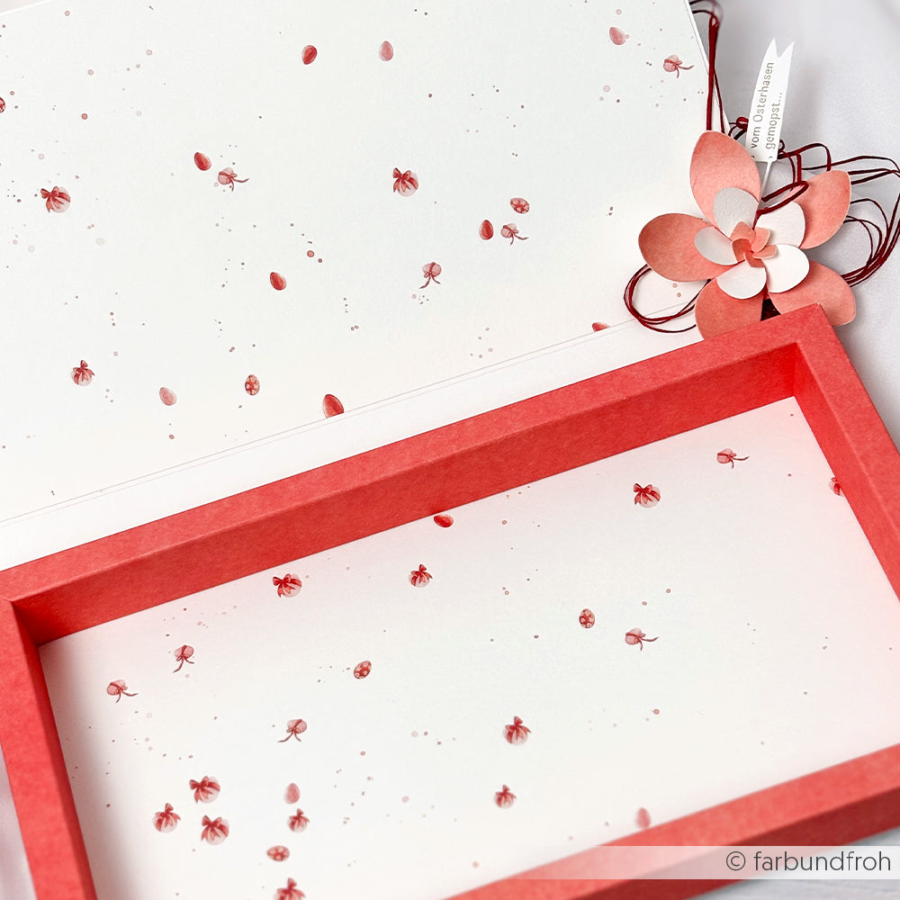 Weißes Papier von Alexandra Renke mit kleinen roten Marienkäfern, einem roten Rahmen und einer Papierblume - ideal für Buchbinderei oder Papierprojekte. Passt perfekt zum Designpapier Ostereierreigen Rosarot.