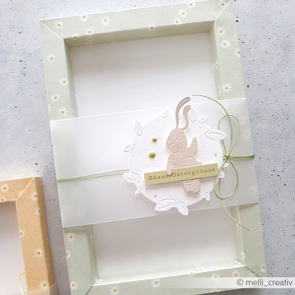 Dekorativer pastellgrüner Rahmen von Alexandra Renke mit Margeritenreigen auf Salvia-Designpapier, Gänseblümchenmuster, Papierhase und Ostergruß - ideal für frühlingshafte Papierprojekte.