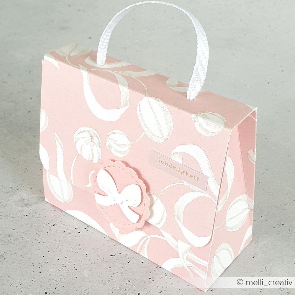 Rosa Geschenktüte mit weißem Muster von Alexandra Renke aus Designpapier, mit weißem Bandhenkel und Schönheitsetikett - ideal für Papierprojekte wie das Verschenken oder Überreichen von Tulpen auf Rosa.