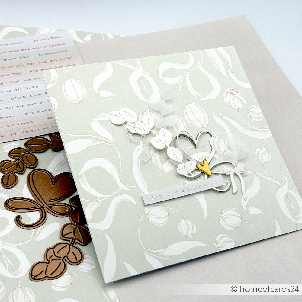 Eine handgefertigte Karte von Alexandra Renke aus Designpapier zeigt ein Blumenmuster, zwei Herzen und den Text "Herzlichen Glückwunsch".