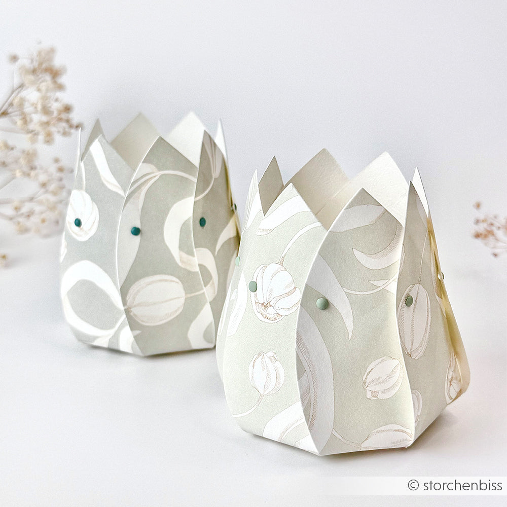 Zwei pastellfarbene, tulpenförmige Geschenkboxen mit floralen Mustern aus Alexandra Renke Designpapier stehen auf einer weißen Fläche - perfekt für charmante Papierprojekte wie Tulpen auf Elegant-Grün.