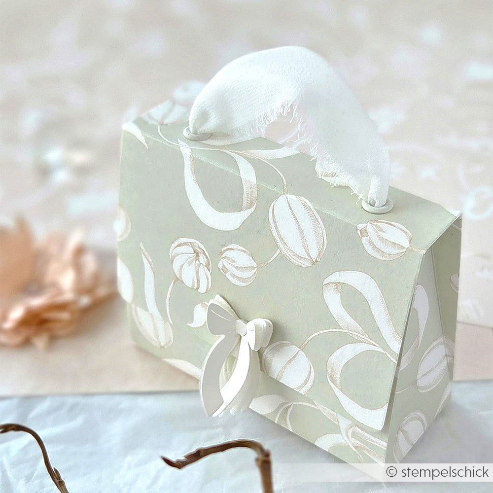 Hellgrüne, geblümte Geschenkschachtel mit Stoffgriff und Schleife aus Alexandra Renke Tulpen Designpapier, ausgestellt auf einer hellen Fläche mit weichem Dekor - ideal für elegante Papierprojekte.