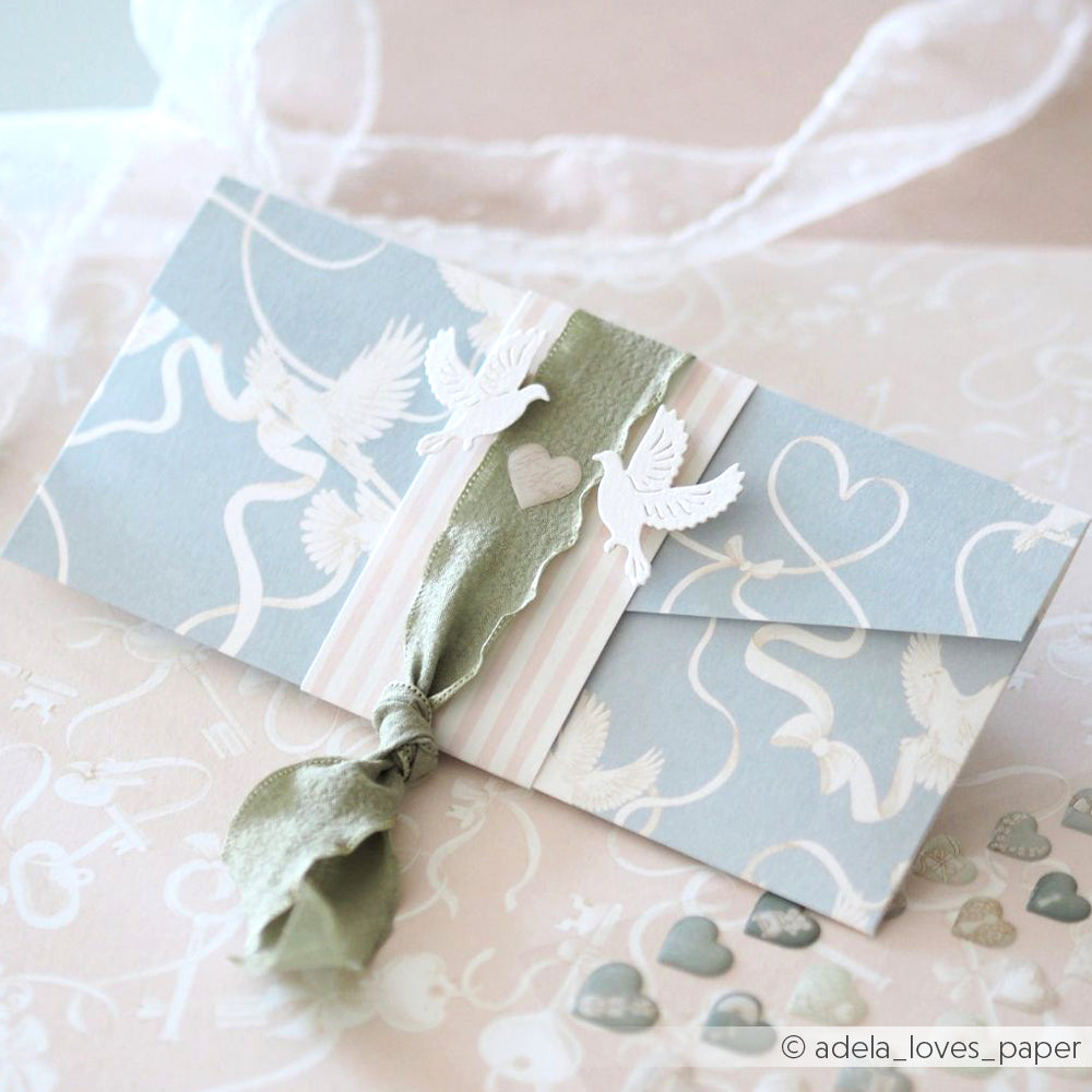Elegante blau-weiße Hochzeitseinladung mit Tauben, Herzen und einer grünen Schleife auf romantisch gemustertem Designpapier von Alexandra Renke - ideal für Papierprojekte oder stilvolle Grußkarten.