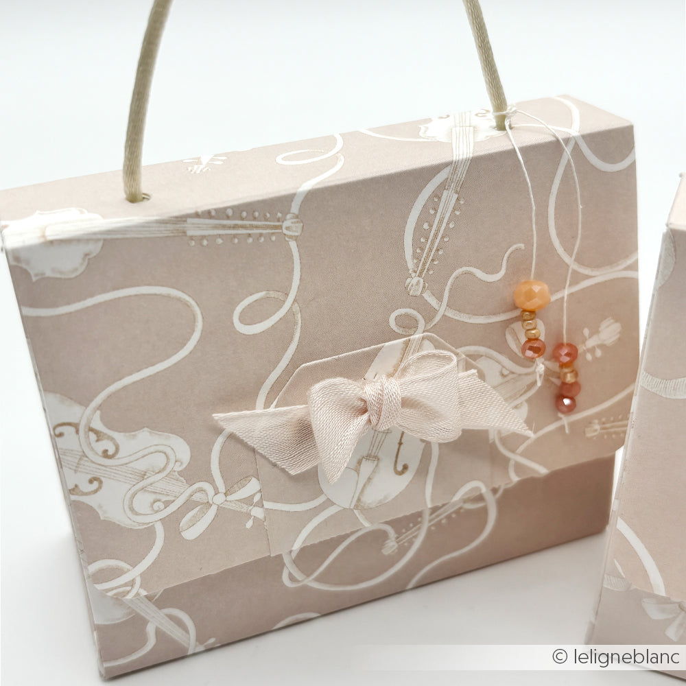 Eine zartrosa Geschenktasche von Alexandra Renke mit Schleife, zarten weißen Mustern und Perlenakzenten - ideal für Papierprojekte mit Designpapier oder in Kombination mit Geigen auf Elegant-Beige Themen.
