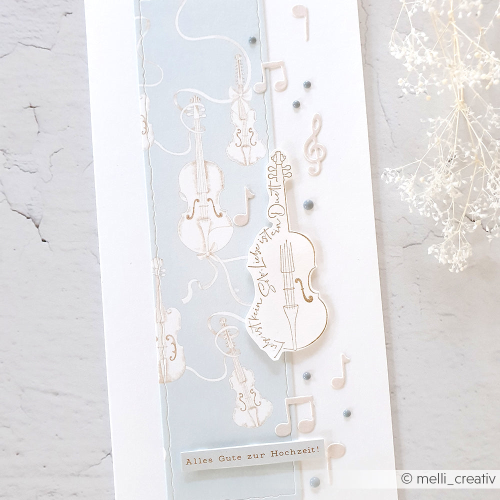 Elegante Hochzeitskarte für Alexandra Renke mit Geigen, Noten und dem Text "Alles Gute zur Hochzeit!" auf einem pastellfarbenen Designpapier-Hintergrund. Ideal zum Basteln von einzigartigen Grußkarten.