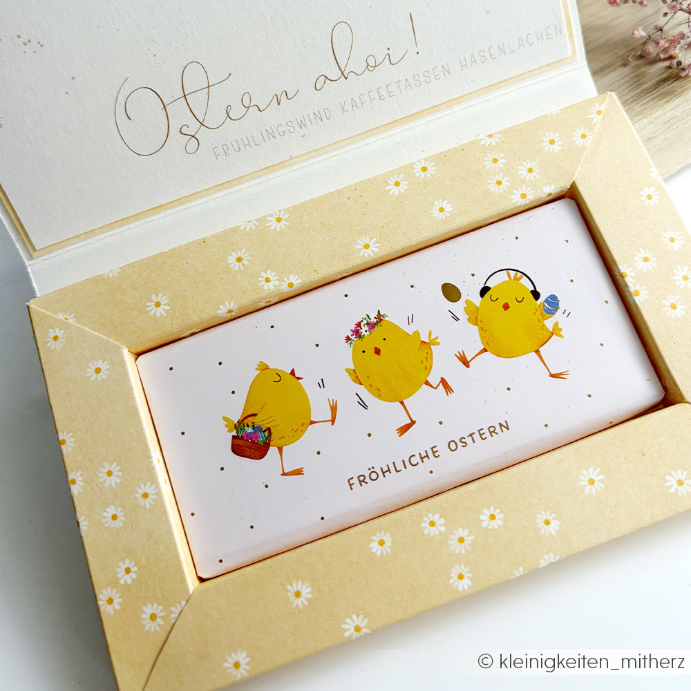 Eine niedliche Karte von Alexandra Renke mit drei Cartoon-Küken und "Fröhliche Ostern" auf Deutsch, umrahmt von einer floralen Bordüre, inspiriert von Lieblingsblüten Designpapier.