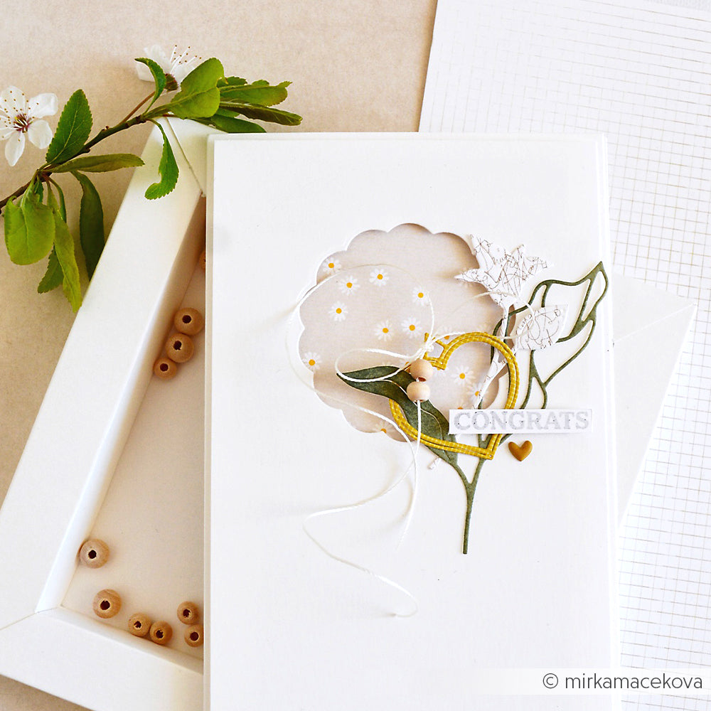 Handgefertigte weiße Grußkarten mit Blumen- und Herzdekoration, hergestellt aus Alexandra Renke Designpapier Lieblingsblüten, präsentiert von einer offenen Schachtel und Holzperlen - ideal für Ihre nächsten Papierprojekte.