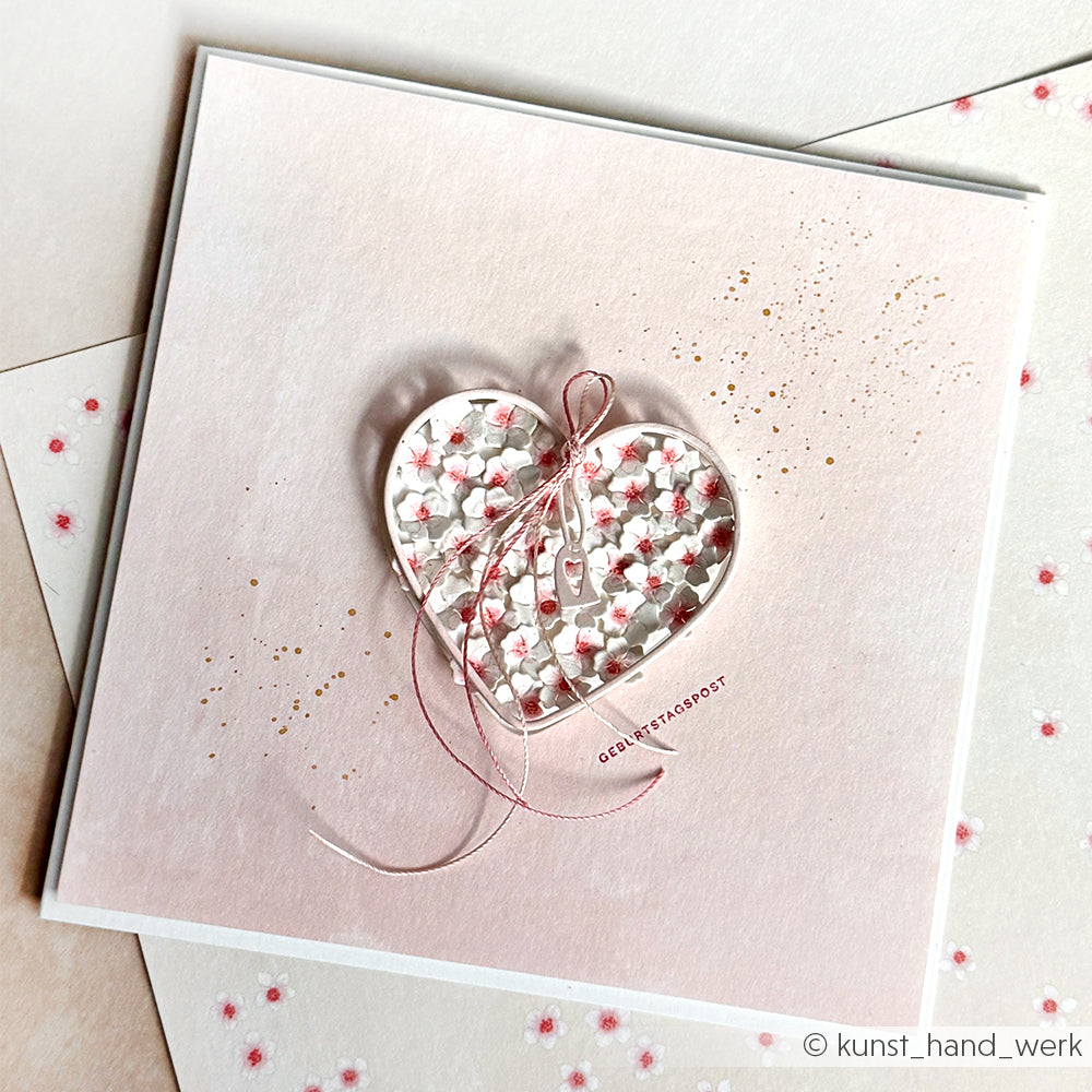 Die handgefertigten Grußkarten von Alexandra Renke zeigen ein gemustertes Herz, eine rosa Schleife, florale Details und goldene Punkte auf hochwertigem Designpapier - perfekt für elegante Papierprojekte.