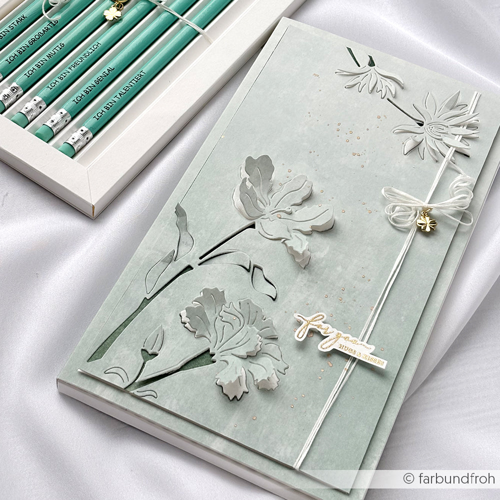 Elegantes florales Notizbuch von Alexandra Renke mit erhabenen Blumenmustern auf Calm Jadegrün Designpapier, weißem Lesebändchen und passenden grünen Stiften in einer Box - ideal für Papierprojekte oder Buchbindereien - präsentiert auf luxuriösem Satinstoff.