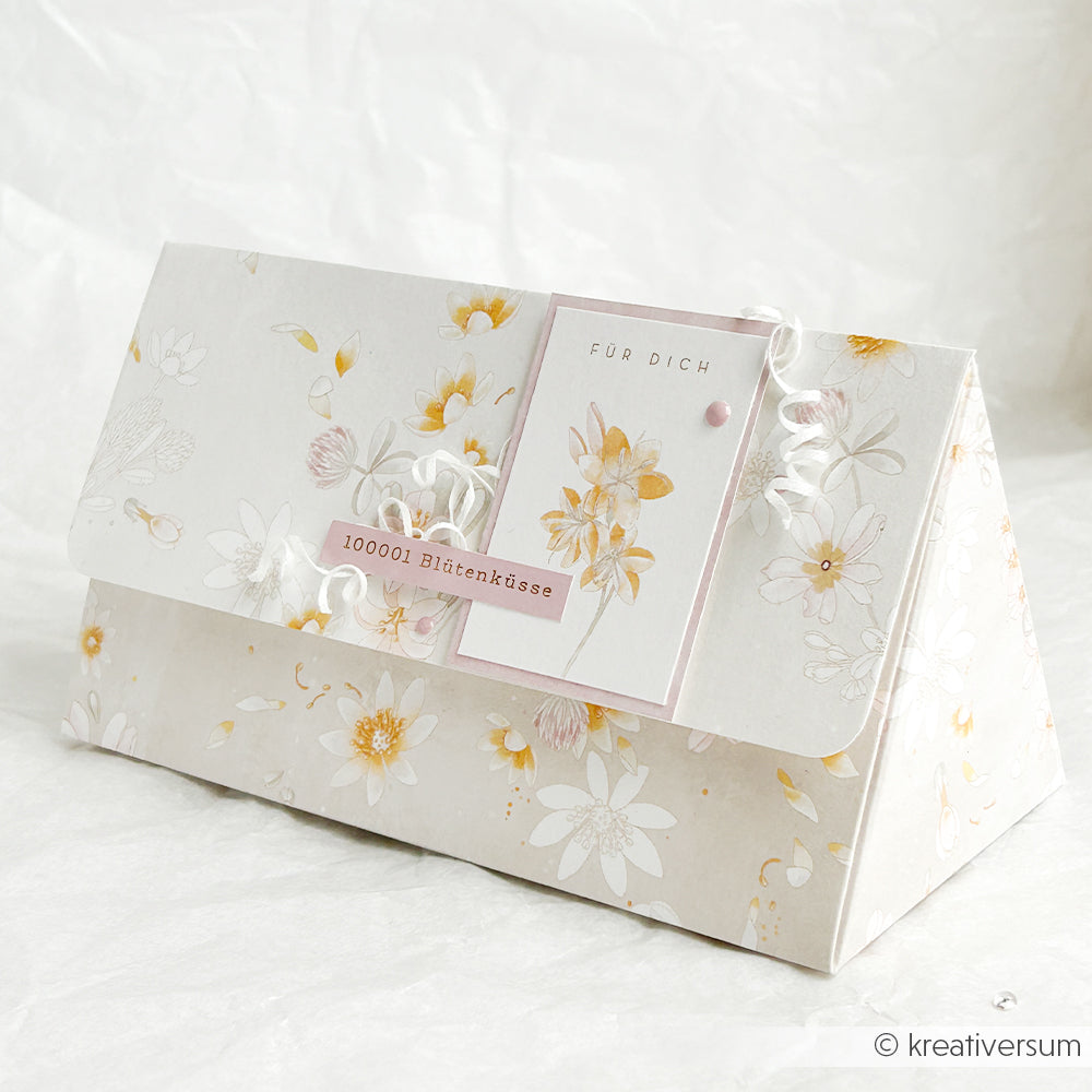 Die floral gemusterte Geschenkbox von Alexandra Renke aus hochwertigem Designpapier ist mit einem "Für Dich"-Anhänger und "100001 Blütenküssen" versehen - ideal für stilvolle Papierprojekte.