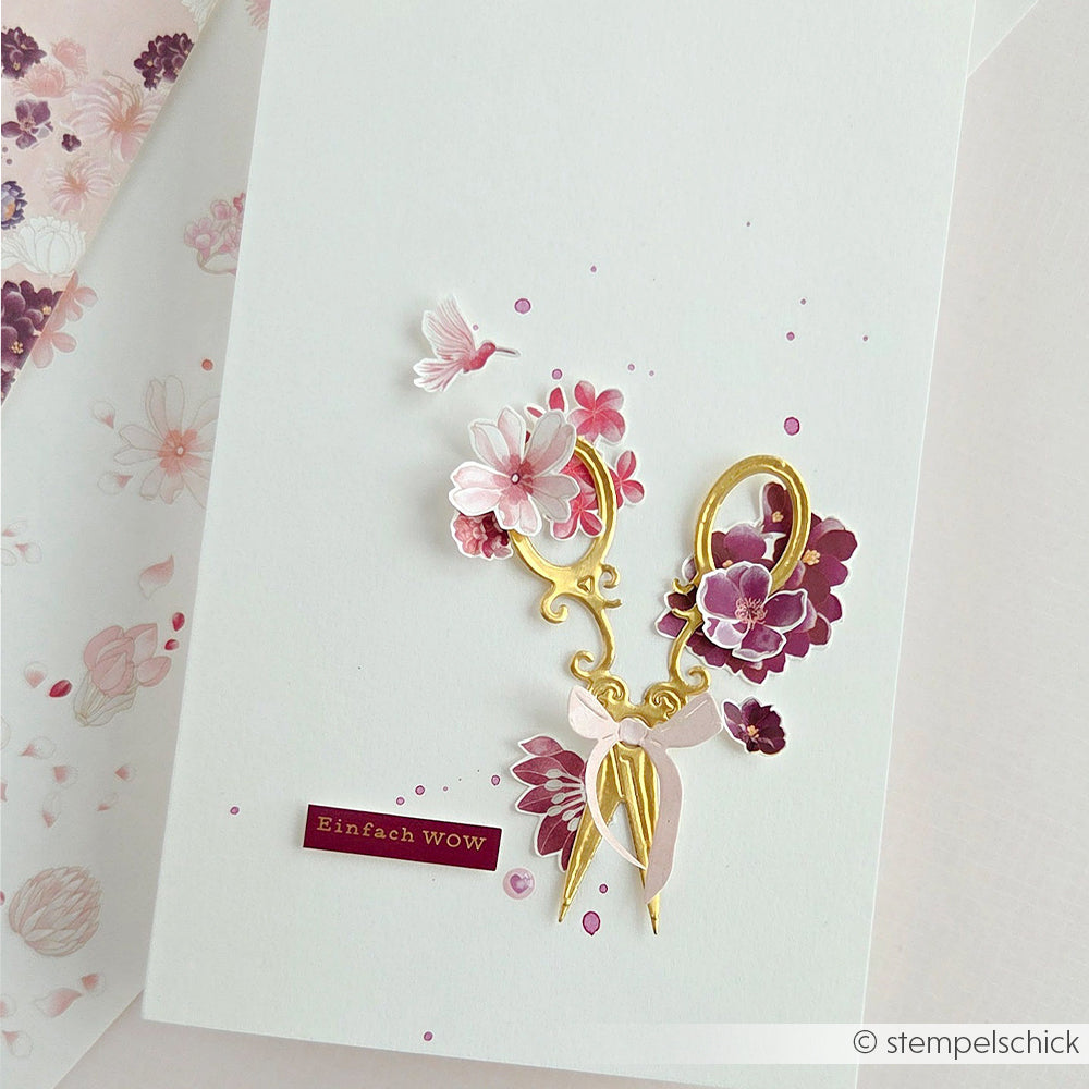 Handgefertigte Karte von Alexandra Renke mit rosa und lila Blumen in einem Blumenmuster, einer goldenen Schere, Akzenten aus Designpapier und einem „Einfach WOW“-Schriftzug auf weißem Hintergrund.