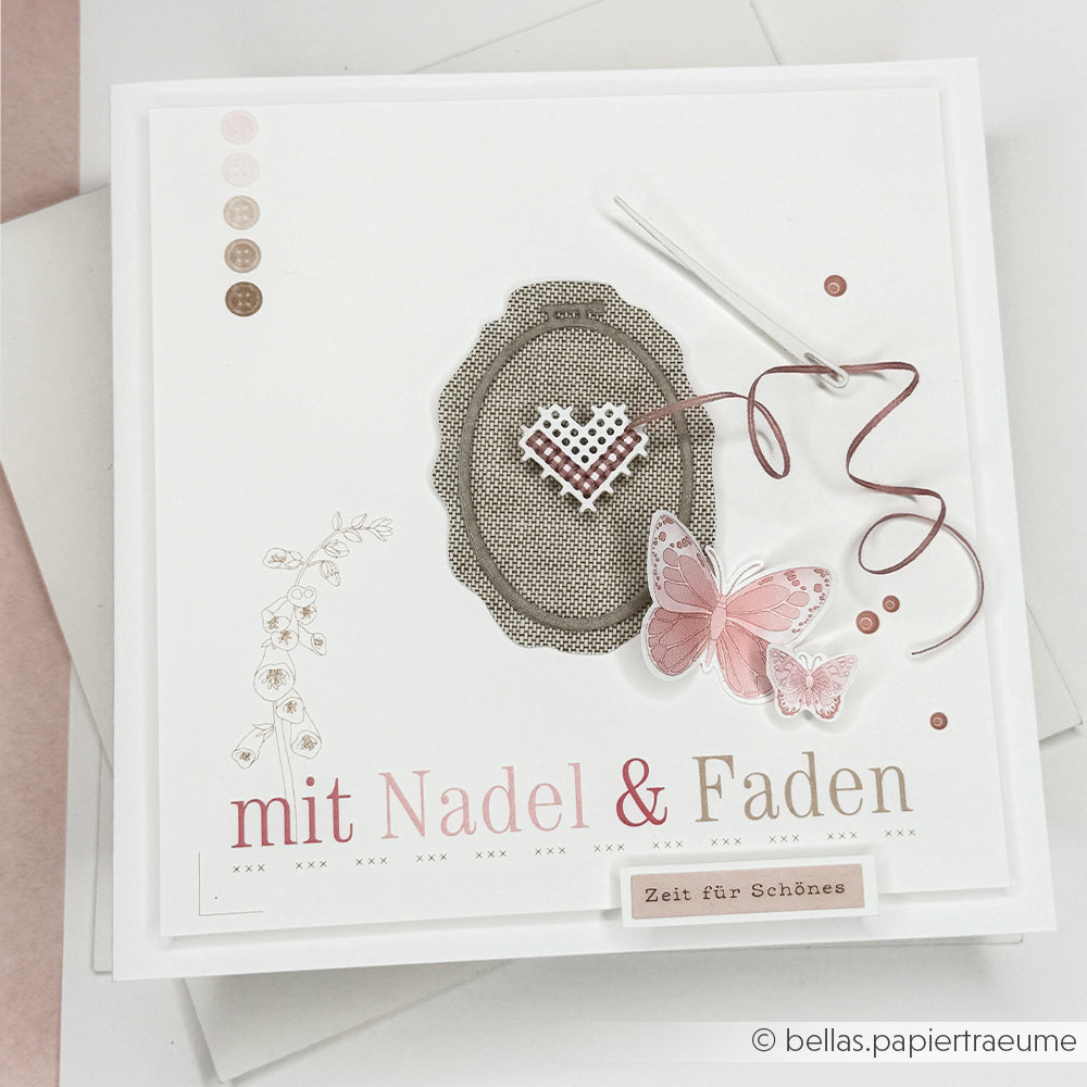Handgefertigte Karte von Alexandra Renke mit einem Herz, einem Schmetterling, einer Nadel, Faden und dem deutschen Text „mit Nadel & Faden“. Hergestellt aus wunderschönem Designpapier – ideal für Fans von Papierprojekten oder Buchbinderei.