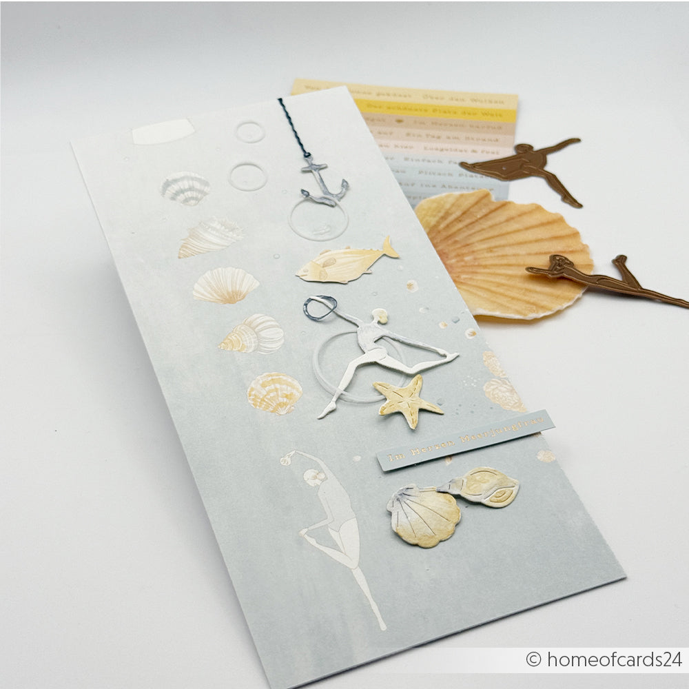 Handgefertigte Karte von Alexandra Renke mit Stanzmotiven zum Thema Meer – Muscheln, Fische, Anker und die „Florale Meeresfigurine Jadeblau“ – auf grauem Hintergrund. Hergestellt aus hochwertigem Designpapier, ideal für Papierprojekte.