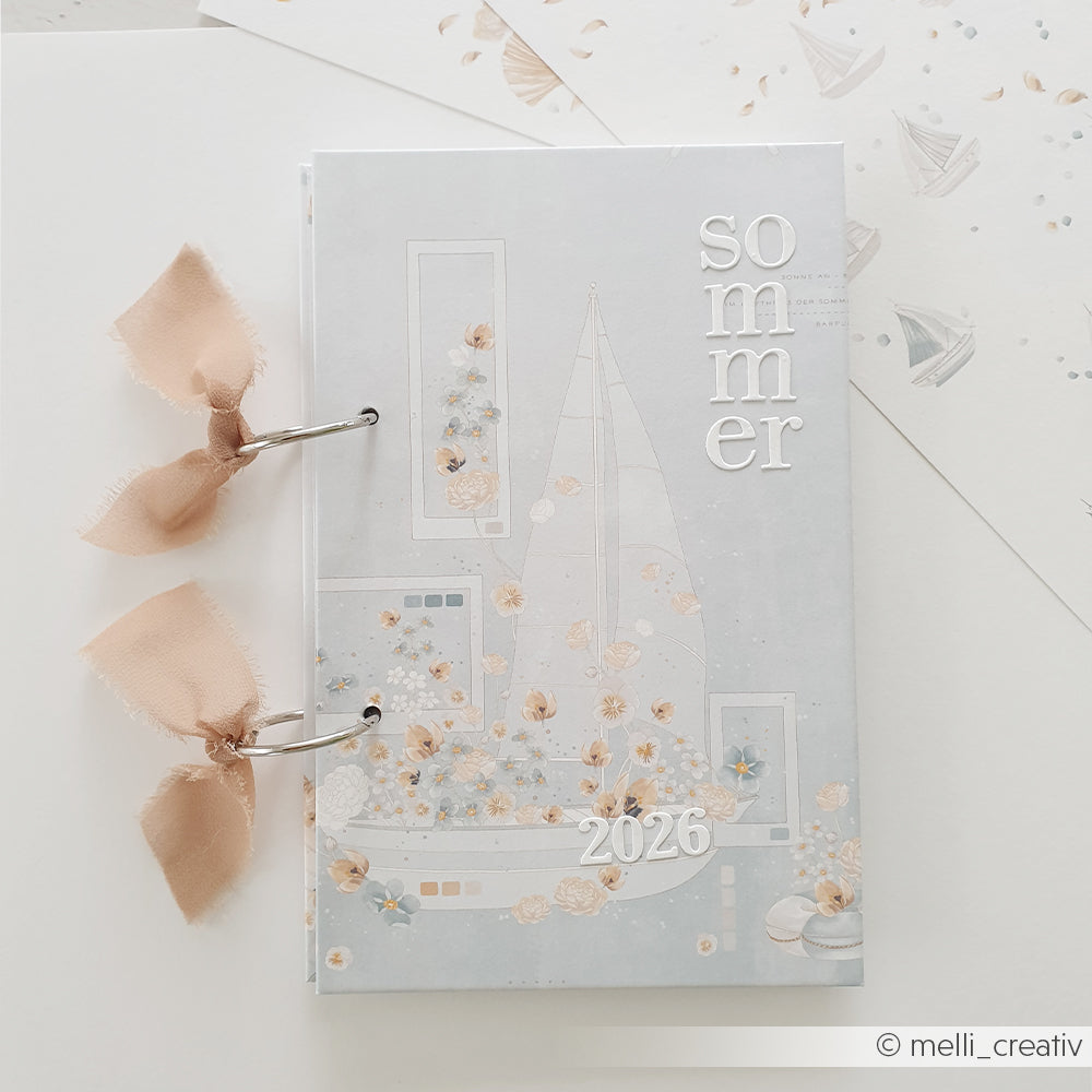 Ein pastellfarbener Sommer 2026 Planer von Alexandra Renke mit rosa Bandringen und einer floralen Schiffskomposition, dargestellt auf Premium Designpapier mit weißem Hintergrund.