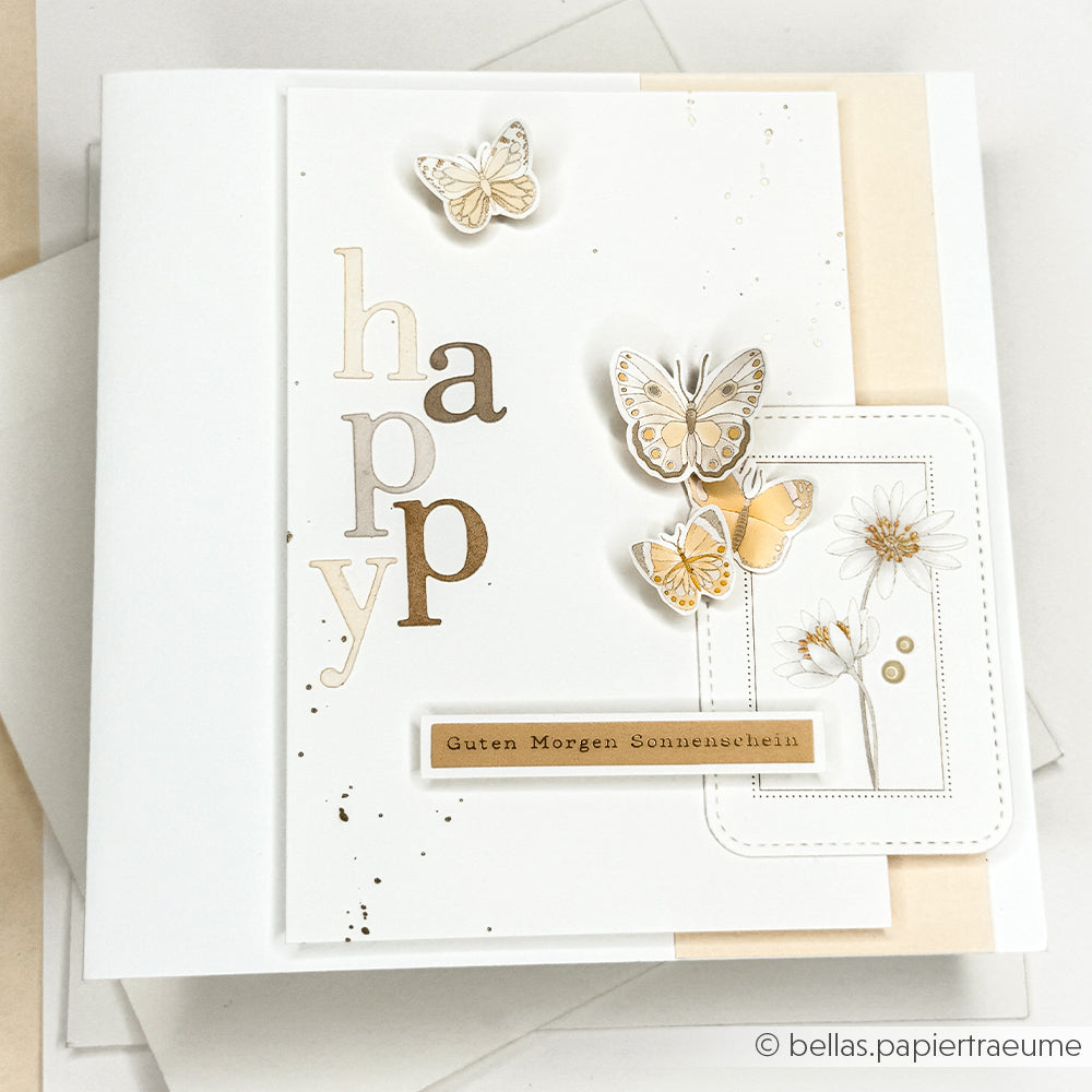 Handgemachte Karte von Alexandra Renke mit geschichtetem Designpapier, Schmetterlingen in einem floralen Muster, Blumen und den Worten "happy" und "Guten Morgen Sonnenschein" - ideal für einzigartige Papierprojekte.