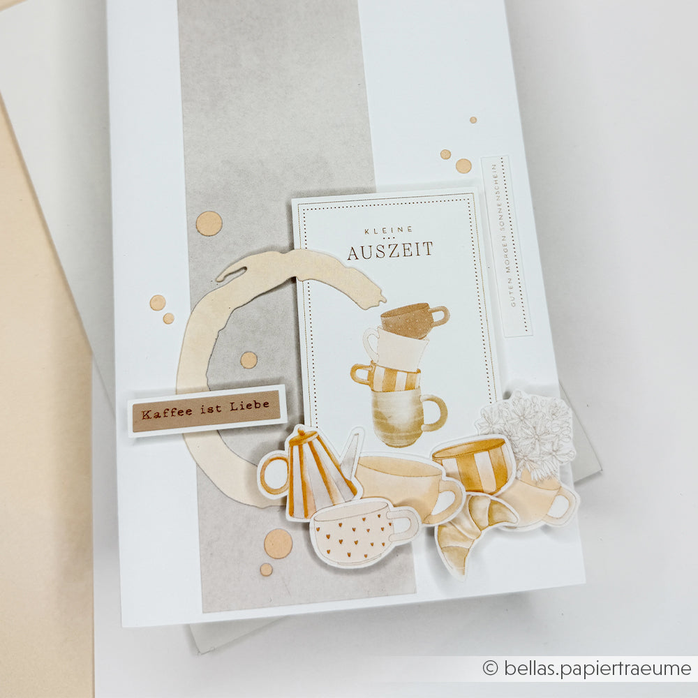 Handgemachte Karte mit Kaffeetassen, Blumen und deutschem Text ("Kaffee ist Liebe" und "Kleine Auszeit"). Hergestellt mit Alexandra Renke's Designpapier und Floraler Kärtchenbogen Gelbgrün für eine einzigartige Note.