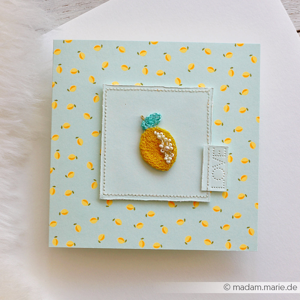 Quadratische Karte mit kleinen gelben Zitronenmotiven und einem aufgestickten gelben Zitronenmotiv in der Mitte, gefertigt aus Designpapier „Summer Special Zitronen“. Ideal für Papierprojekte oder um mit Akzenten aus Neonpapier einen farbenfrohen Touch zu setzen.