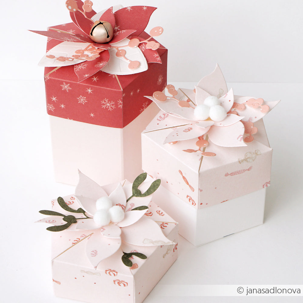 Drei Geschenkboxen, verziert mit handgefertigten Papierblumen aus Designpapier.