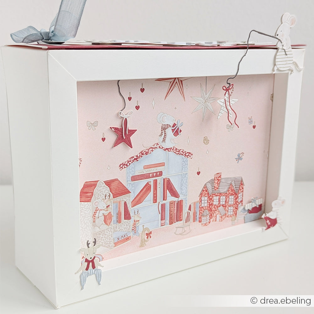 Ein mehrschichtiger Schattenkasten mit Weihnachtsmäusen in einem bezaubernden Weihnachtsdorf.