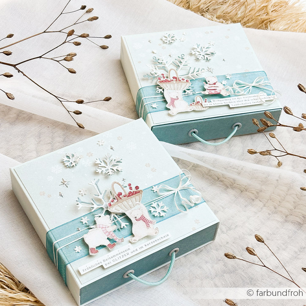 Zwei hellblaue Geschenkboxen, verziert mit Eisbären und Schneeflocken, für Winterfreuden-Projekte.