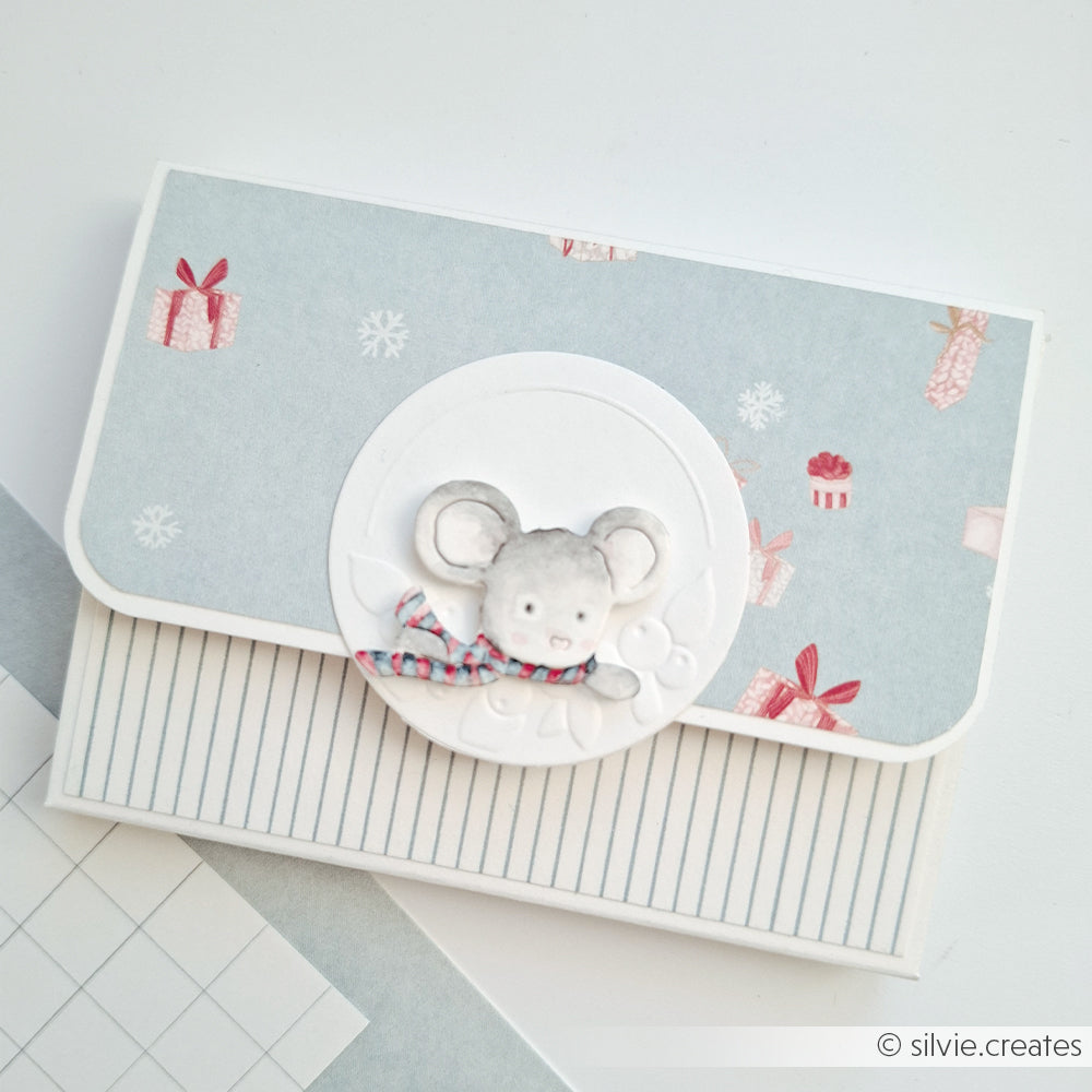 Handgefertigte Karte mit einer Papiermaus, die einen Schal trägt, hergestellt aus dekorativem Designpapier.