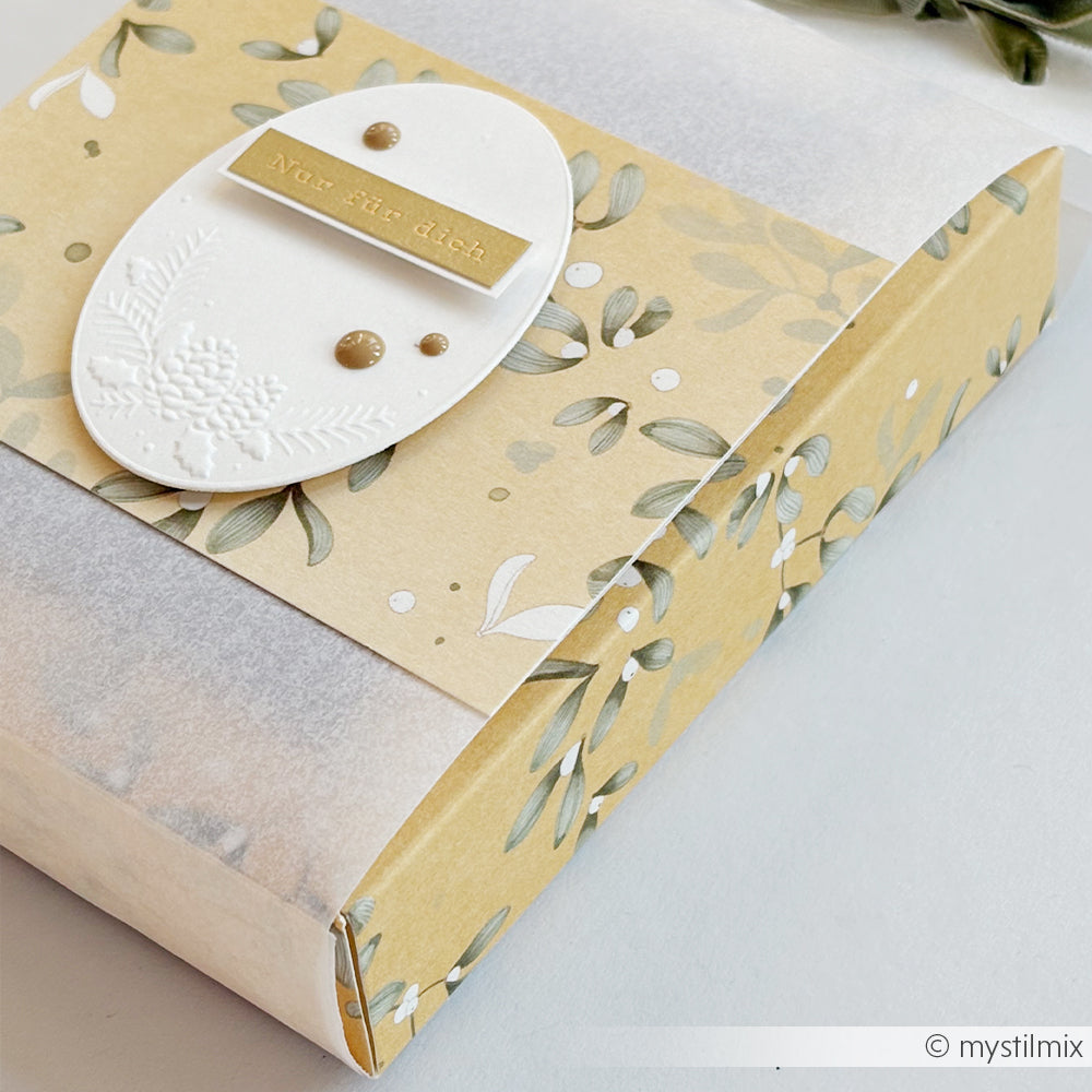 Geschenkbox aus Papier im Mistelwirbel-Design mit einem ovalen Anhänger mit der Aufschrift Nur für dich.