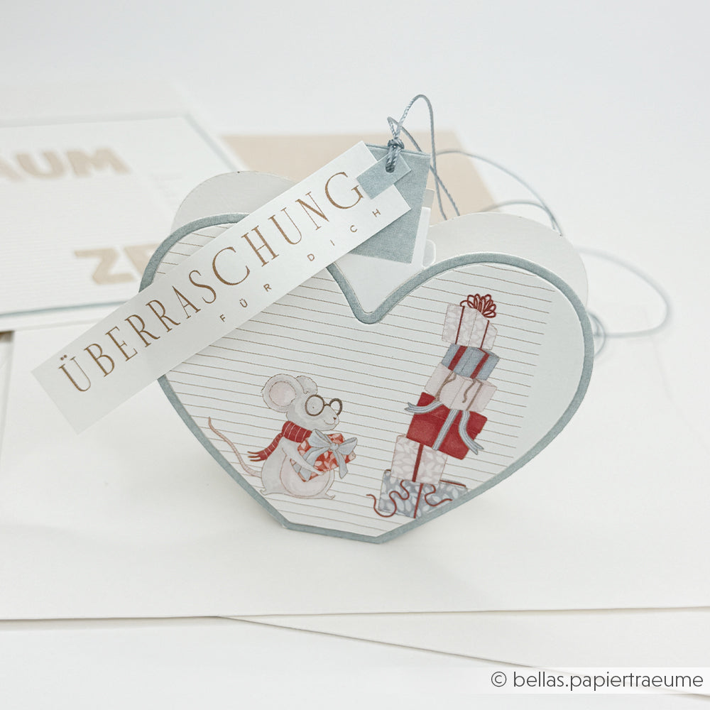 Herzförmige Geschenkbox mit einer Maus und Geschenken – ideal für Bastelprojekte mit Weihnachtsmotiven.