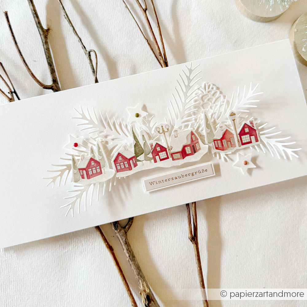 Handgefertigte Karte mit ausgestanzten roten Häuschen und Tannenzweigen aus Winterstadt-Designpapier.