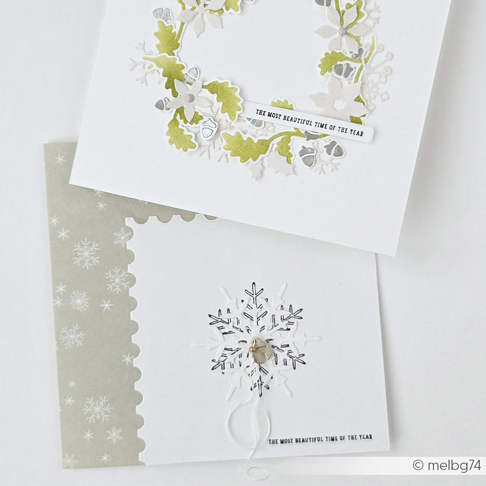 Zwei handgefertigte Grußkarten mit einem botanischen Kranz und einem Schneeflockenmotiv.