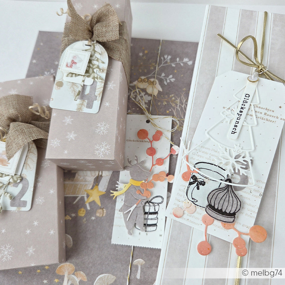 Eingepackte Weihnachtsgeschenke, verziert mit Geschenkanhängern, Bändern und Papier mit Schneeflockenmuster.