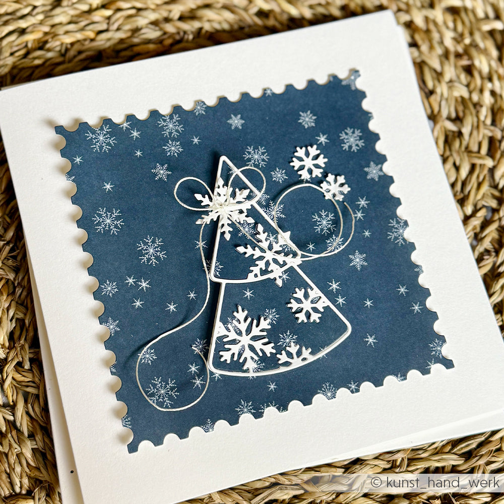 Eine quadratische, handgefertigte Karte aus hochwertigem blauem Designpapier mit Schneeflockenmuster und einem Weihnachtsbaum mit Drahtumriss.