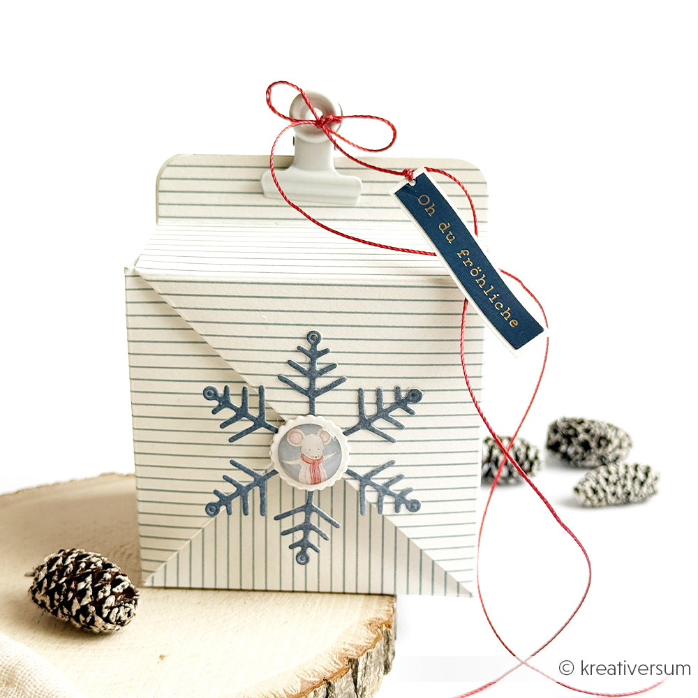 Geschenkbox mit Streifenmuster, verziert mit einer Schneeflocke, einer Mausillustration und einem Anhänger mit der Aufschrift Zarte Streifen.