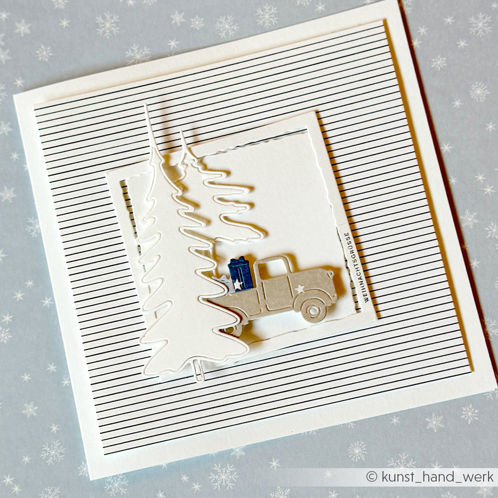 Handgefertigte Weihnachtskarte mit einem Lastwagen, einem Geschenk und Tannenbäumen auf Zarte Streifen Premiumblau-Papier.