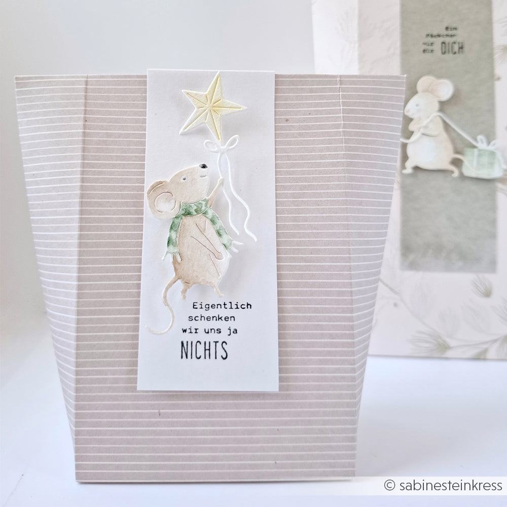 Gestreifte Geschenktüte für Papierbastelprojekte mit einer Maus, die einen Stern hält, und dem Text Eigentlich schenken wir uns ja NICHTS.