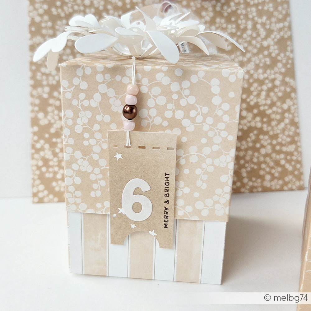 Kleine Geschenkbox, verpackt in gestreiftem Aquarellpapier mit einem Anhänger mit der Nummer 6.