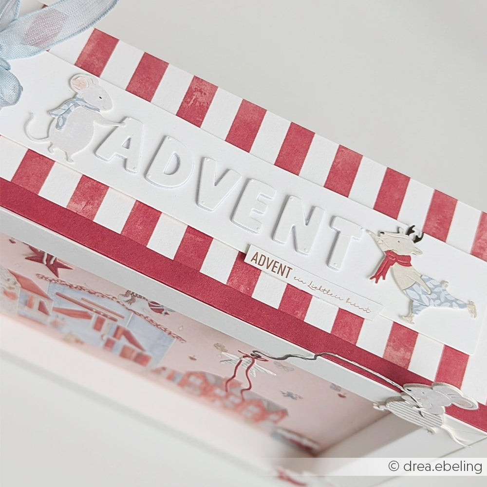 Eine Adventsbox mit aquarellfarbenen Streifen in edlem Rot, verziert mit Tiermotiven.