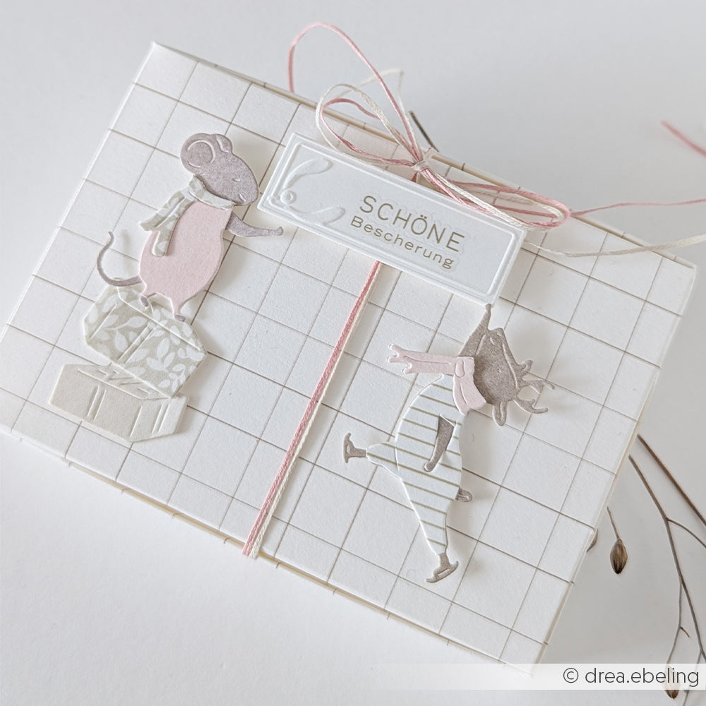 Geschenkbox aus Designpapier mit Rastermuster, zwei Maus-Ausschnitten und einem Anhänger mit der Aufschrift SCHÖNE Bescherung.