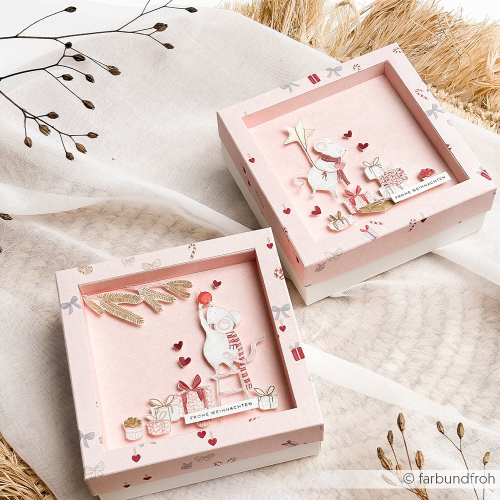 Zwei quadratische Mimi-Sanftrosa-Geschenkboxen mit 3D-Papierausschnitten von Mäusen und Geschenken.